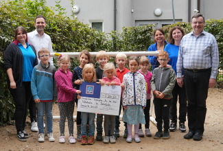 Filialleiterin Sabrina Meister (links) und Regionalverkaufsleiter Christoph Obermeier (2. von links) übergeben die Spende an Pfarrer Dr. Roland Kurz (rechts), Cornelia Ostasch (2. von rechts) und Kindergartenleiterin Linda Hirsch (hinten, 3. von rechts).